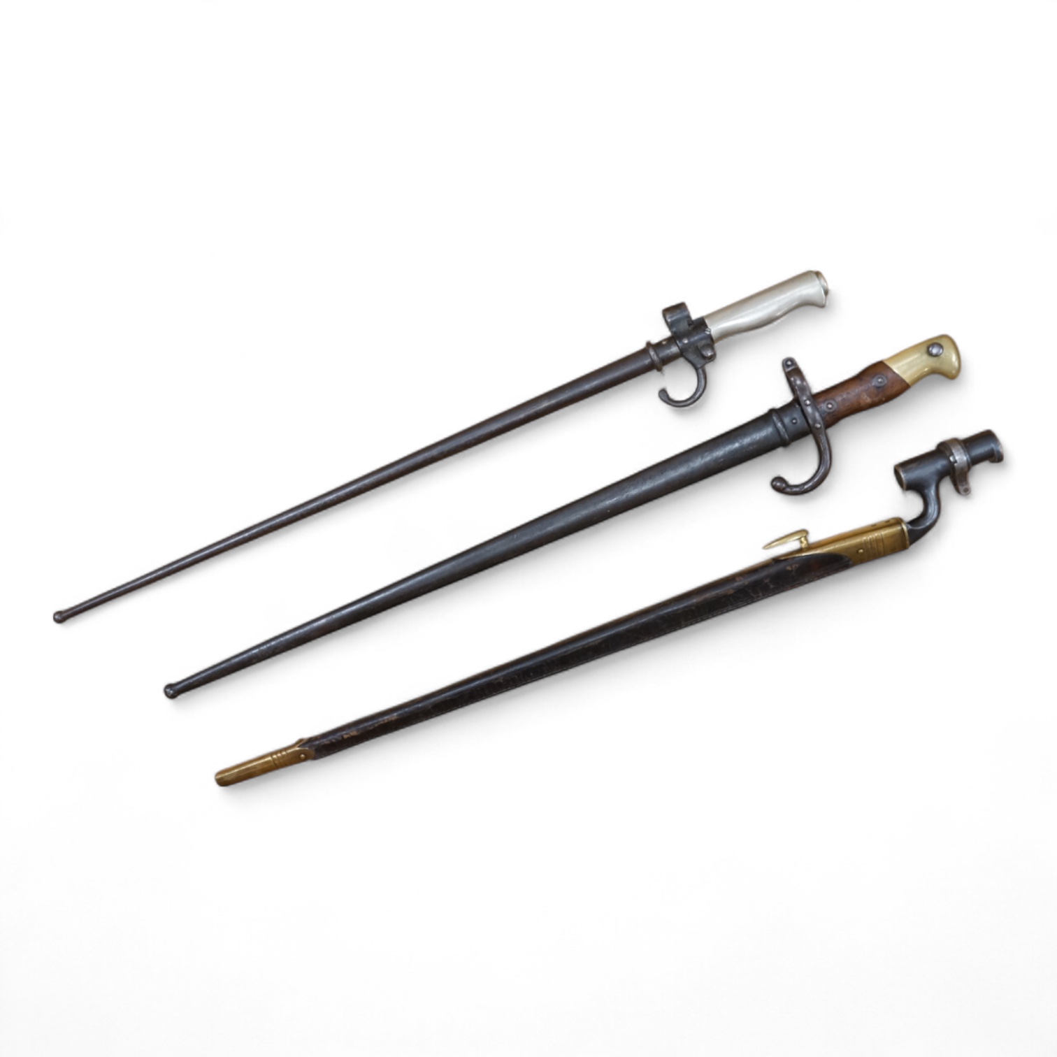 Three bayonets; a gras bayonet, a Lebel bayonet and an Indian Enfield style triangular socket bayonet, all in the original scabbards